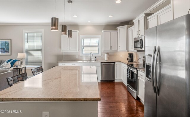 kitchen featuring ornamental molding, a sink, stainless steel appliances, and decorative backsplash
