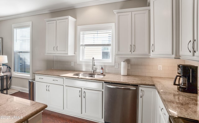 kitchen with dishwasher, white cabinets, a sink, and ornamental molding