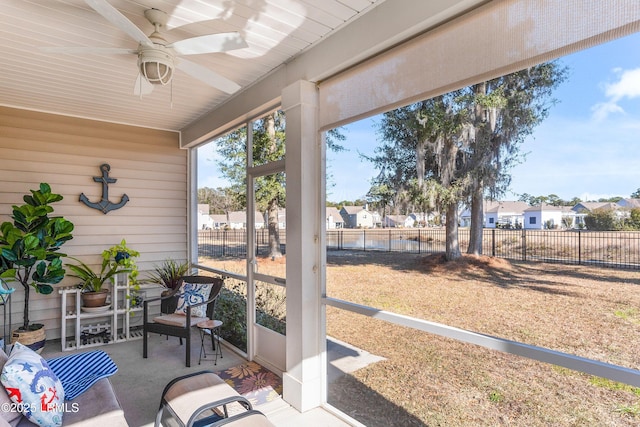 sunroom with a residential view and a ceiling fan