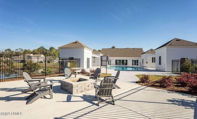 view of patio / terrace with a fire pit, fence, and a community pool