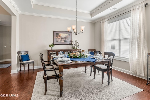 dining room featuring a raised ceiling, dark wood finished floors, baseboards, visible vents, and an inviting chandelier