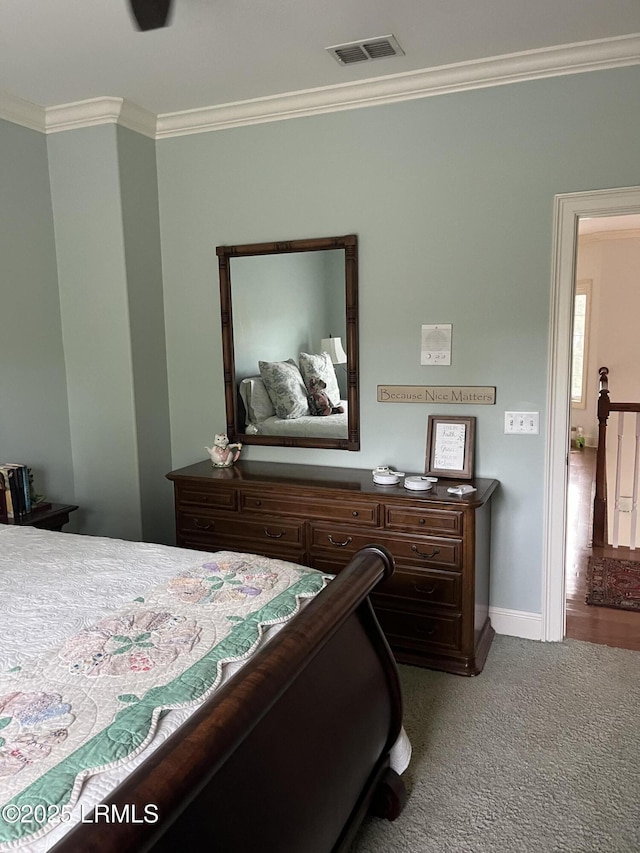 bedroom with ornamental molding, baseboards, visible vents, and carpet flooring