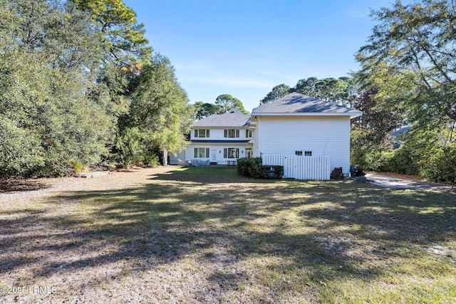 rear view of house featuring a lawn