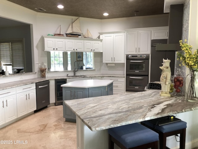 kitchen with wine cooler, dobule oven black, a sink, visible vents, and white cabinets