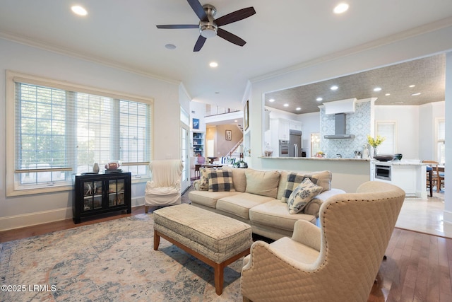 living room featuring recessed lighting, baseboards, crown molding, and wood finished floors