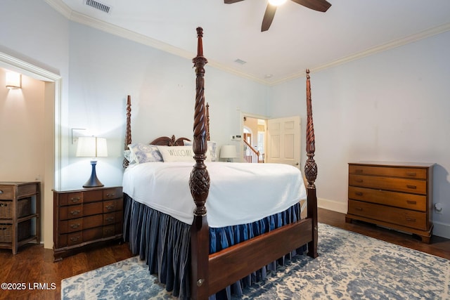 bedroom with baseboards, visible vents, ceiling fan, wood finished floors, and crown molding