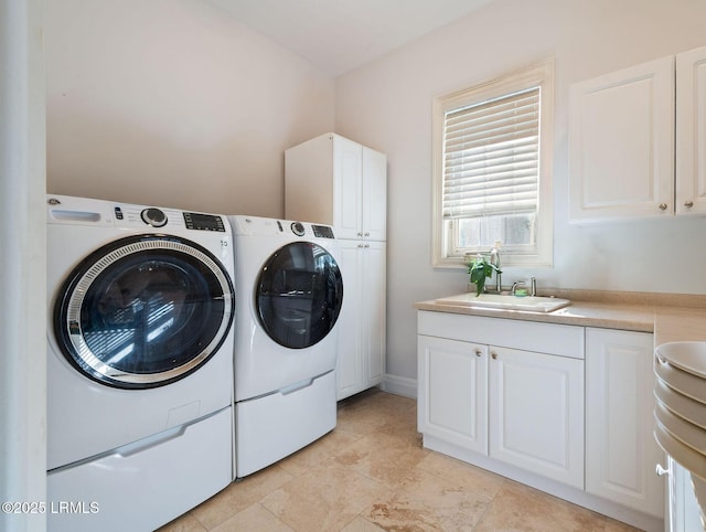 clothes washing area with cabinet space, washing machine and dryer, and a sink