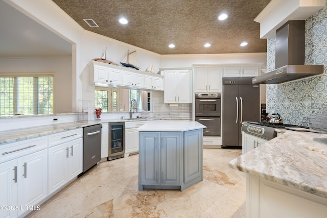 kitchen featuring beverage cooler, range hood, appliances with stainless steel finishes, ornamental molding, and a center island