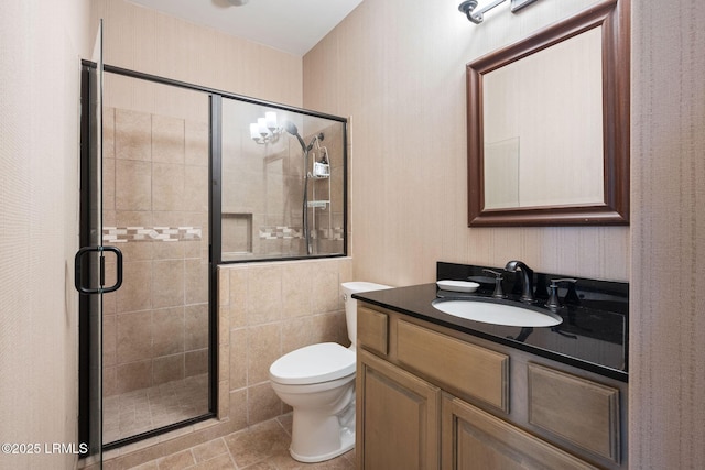 full bathroom featuring a shower stall, toilet, and vanity