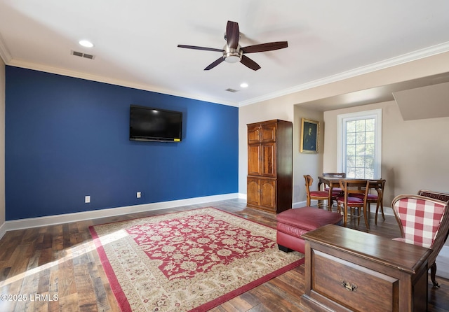 interior space with ornamental molding, visible vents, hardwood / wood-style floors, and baseboards