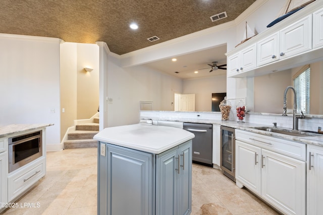 kitchen featuring wine cooler, a sink, visible vents, white cabinetry, and appliances with stainless steel finishes