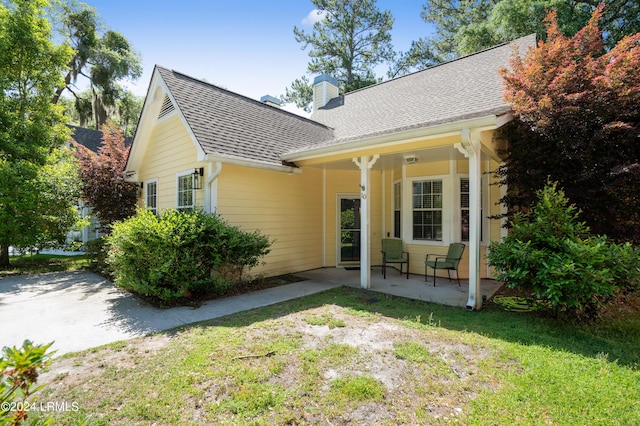 rear view of house featuring a yard and a patio area