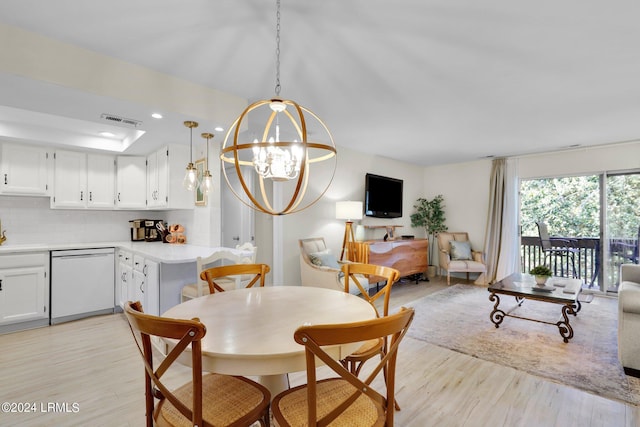 dining area with an inviting chandelier and light hardwood / wood-style floors