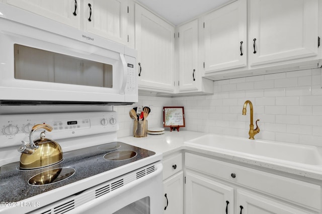 kitchen featuring white cabinetry, sink, white appliances, and decorative backsplash