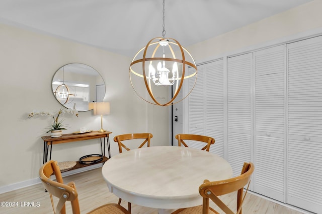 dining space with an inviting chandelier and light hardwood / wood-style flooring