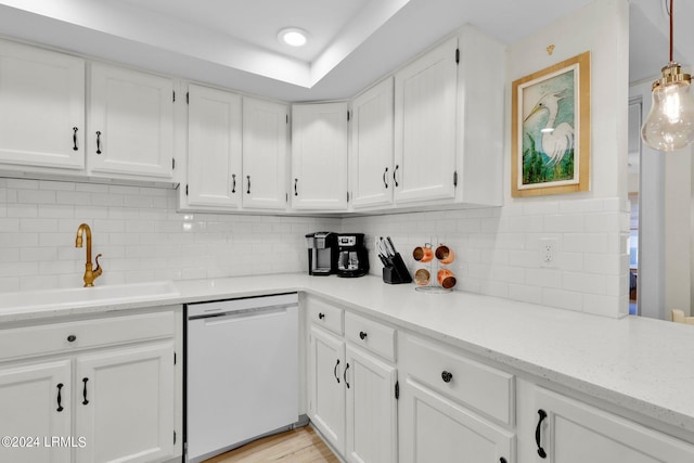 kitchen with tasteful backsplash, pendant lighting, white dishwasher, and white cabinets