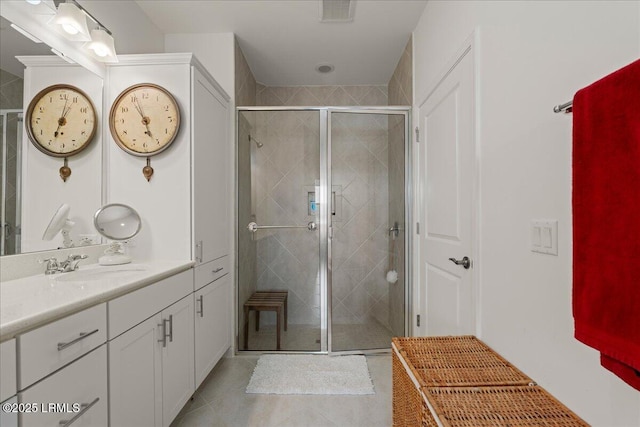 bathroom with an enclosed shower, vanity, and tile patterned flooring