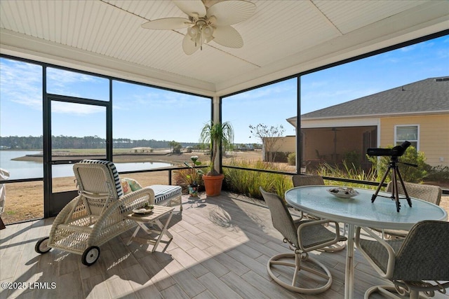 sunroom featuring a water view and ceiling fan