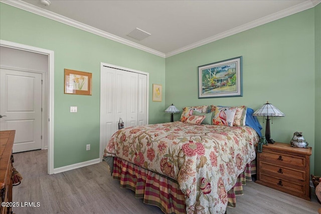 bedroom with crown molding, a closet, and light wood-type flooring