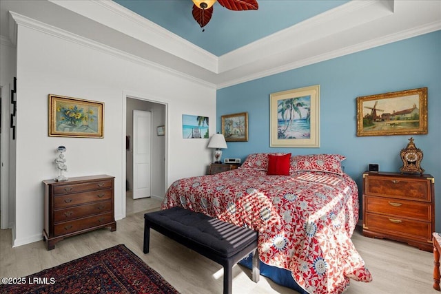 bedroom with crown molding, light hardwood / wood-style floors, a raised ceiling, and ceiling fan