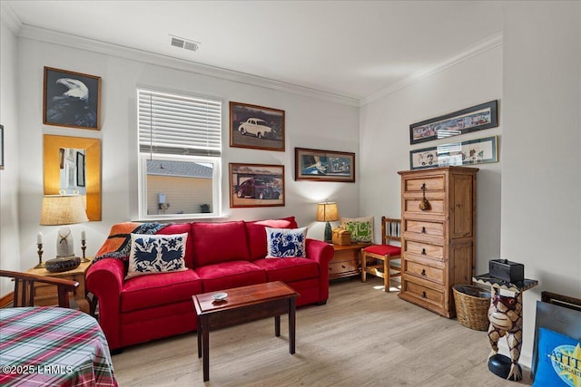 living room featuring ornamental molding and light hardwood / wood-style flooring