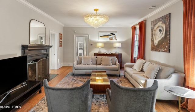 living room with ornamental molding, an inviting chandelier, and light hardwood / wood-style flooring