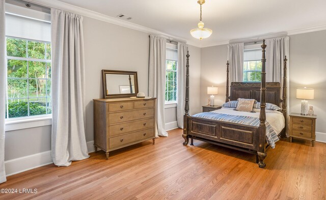 bedroom with ornamental molding and light wood-type flooring