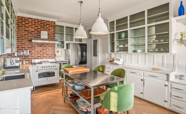 kitchen featuring sink, wall chimney range hood, light parquet floors, white cabinets, and high quality stove