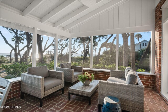 sunroom featuring lofted ceiling with beams