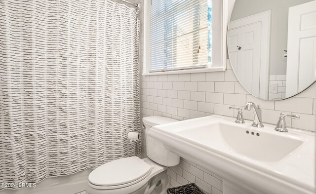 full bathroom featuring sink, tile walls, shower / tub combo, tasteful backsplash, and toilet