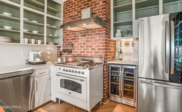 kitchen featuring wine cooler, light parquet floors, wall chimney exhaust hood, and appliances with stainless steel finishes