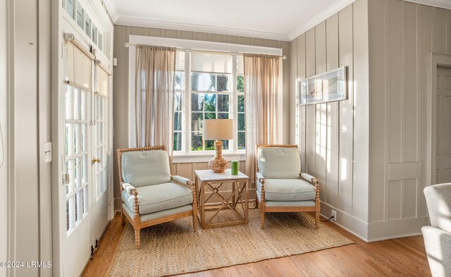 sitting room featuring crown molding and light hardwood / wood-style floors