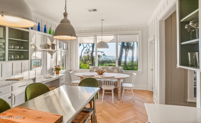 dining room with crown molding and light parquet flooring