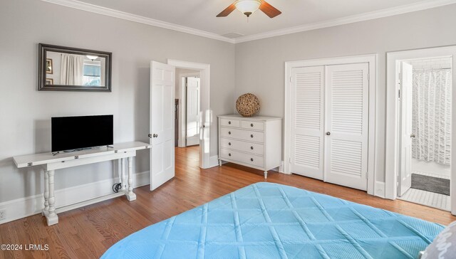 bedroom featuring ensuite bath, ceiling fan, wood-type flooring, ornamental molding, and a closet