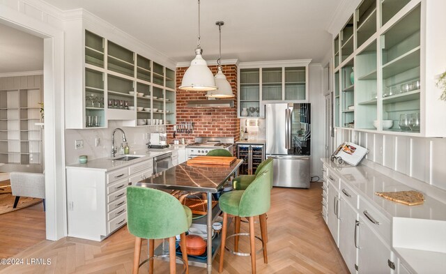 kitchen featuring stainless steel appliances, decorative light fixtures, a kitchen island, and white cabinets