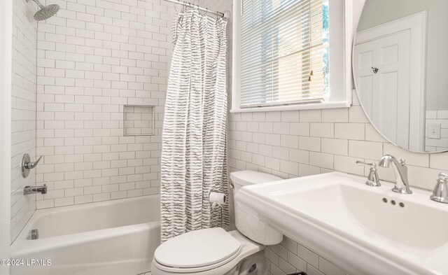 full bathroom featuring toilet, sink, tile walls, shower / bath combination with curtain, and backsplash