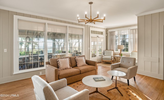 living room featuring crown molding, a chandelier, and light hardwood / wood-style flooring