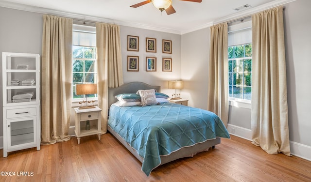 bedroom with hardwood / wood-style flooring, ceiling fan, and ornamental molding