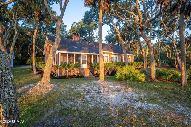 ranch-style home featuring a sunroom and a front lawn