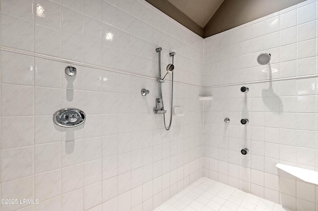 full bath featuring lofted ceiling and a tile shower