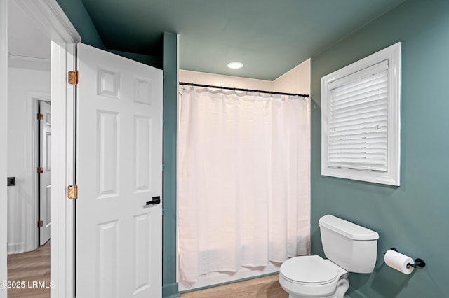 bathroom with wood finished floors, toilet, a shower with curtain, and recessed lighting