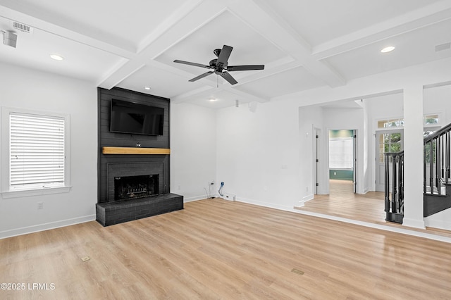 unfurnished living room featuring coffered ceiling, a fireplace, light wood-style floors, baseboards, and ceiling fan