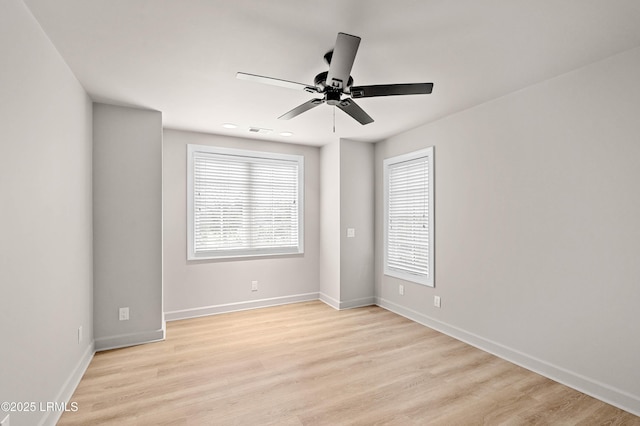 empty room with ceiling fan, healthy amount of natural light, and light wood-style flooring