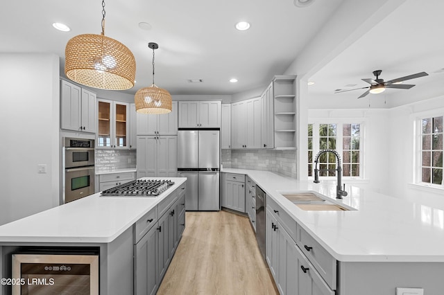 kitchen with a sink, stainless steel appliances, open shelves, wine cooler, and gray cabinets