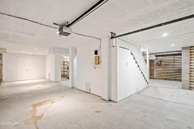 garage with a garage door opener and recessed lighting