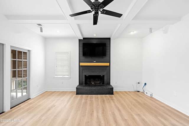 unfurnished living room featuring coffered ceiling, wood finished floors, a brick fireplace, baseboards, and beamed ceiling