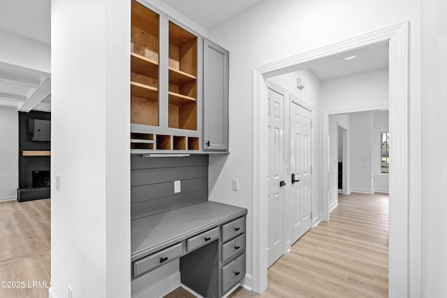 hall with light wood-style floors and baseboards