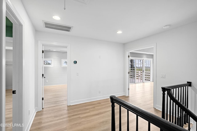hall with an upstairs landing, light wood-style floors, recessed lighting, baseboards, and attic access