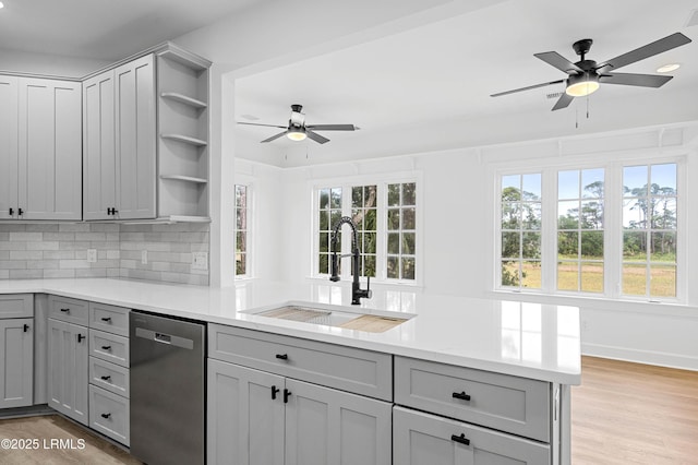 kitchen featuring dishwasher, a ceiling fan, gray cabinetry, a sink, and open shelves