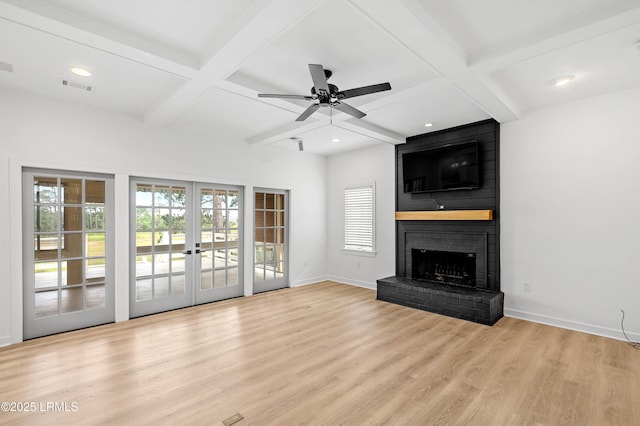 unfurnished living room featuring coffered ceiling, plenty of natural light, wood finished floors, a brick fireplace, and baseboards